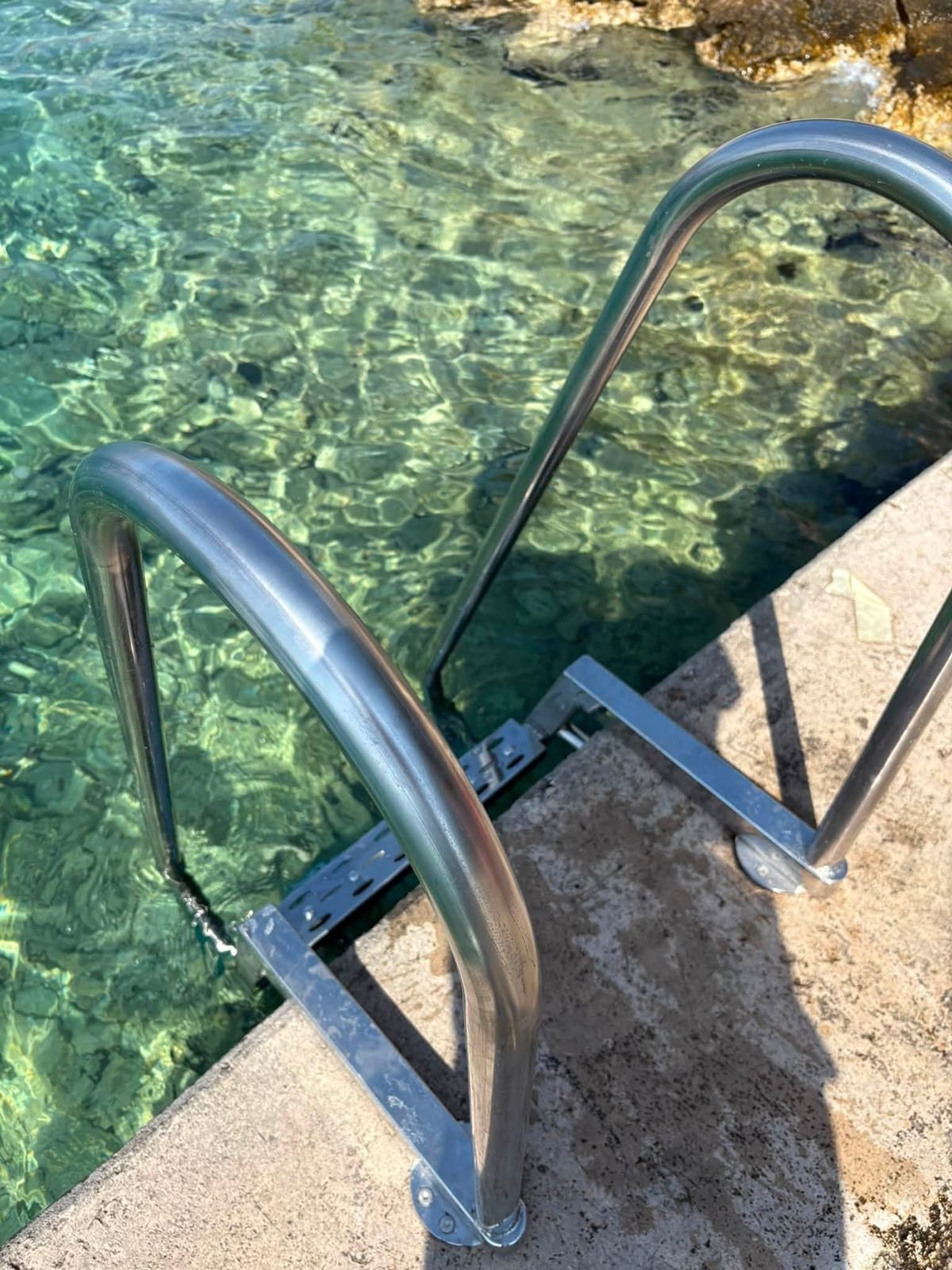 Inox ljestve za ulaz u more, pričvršćene na rub betonskog mola