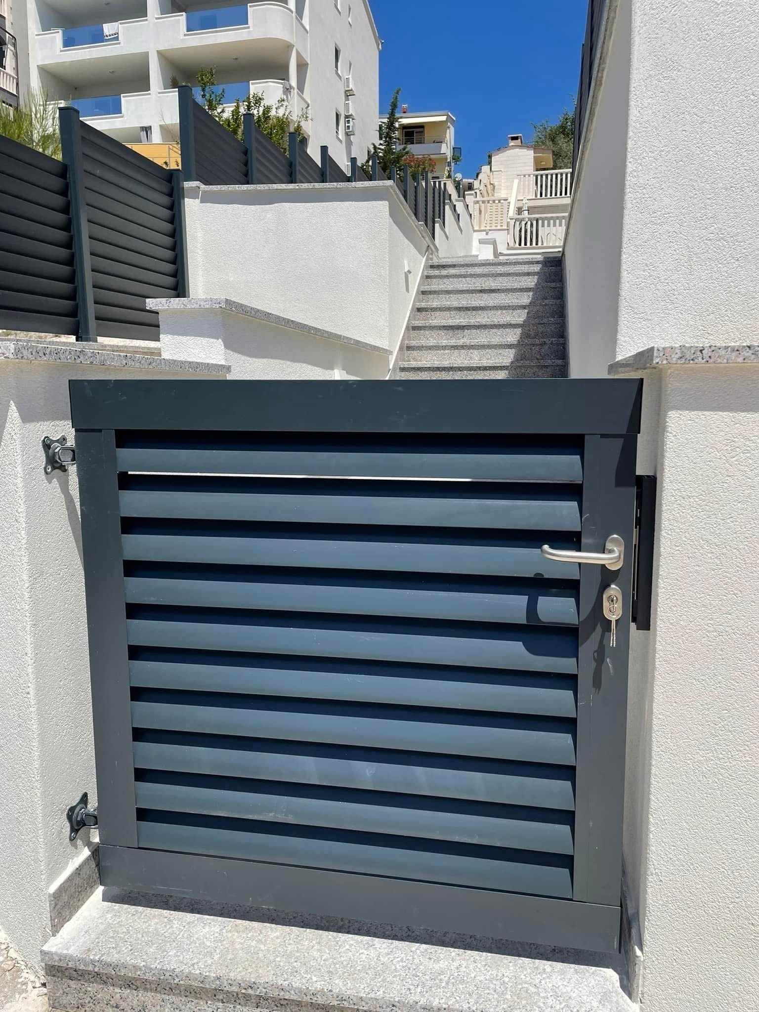 Jednokrilna antracitna vrata s lamelnim ispunom, inox kvakom i cilindrom, ugrađena između zidova uz stubište.